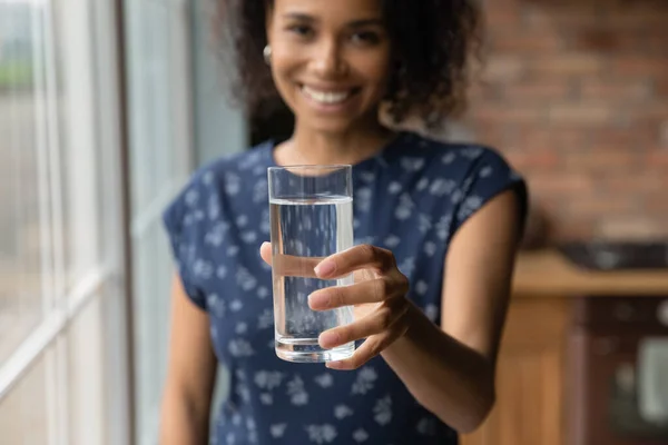 Une femme biraciale souriante recommande de boire de l'eau potable — Photo