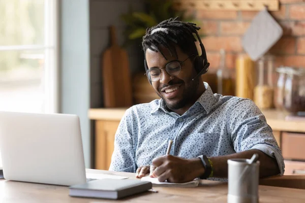 Sorrindo biracial homem em fones de ouvido estudo on-line no computador — Fotografia de Stock