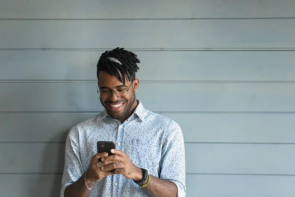 Smiling biracial man browsing modern smartphone gadget — Stok Foto