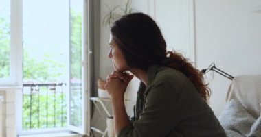 Üzgün, yalnız kadın, üzgün düşünceler içinde kanepeye oturur.