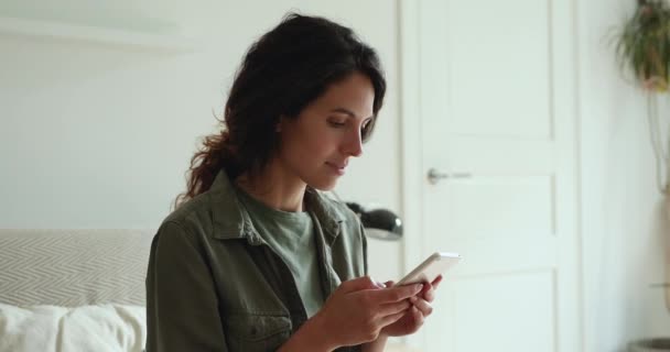 Hübsche Frau mit Smartphone verbringt ihre Freizeit online — Stockvideo