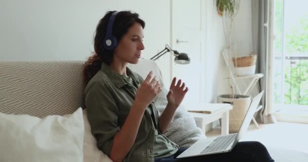 Vrouwen dragen een koptelefoon met laptop en praten via videoconferentie — Stockvideo