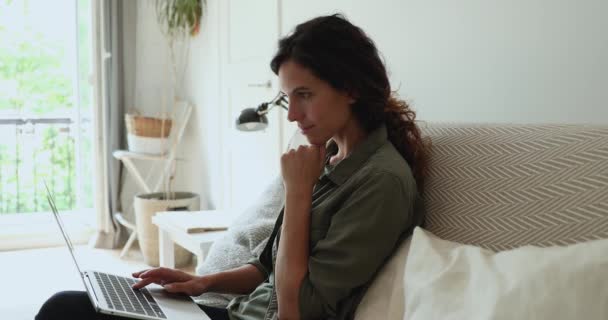 Millennial vrouw gebruik laptop doen telewerken vanuit huis — Stockvideo