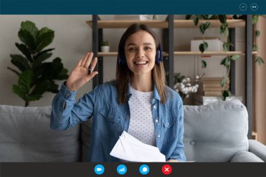 Ekran görüntüsü, kulaklık takan gülümseyen kadın el sallıyor, internetten ders çalışıyor.