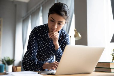 Düşünceli Hintli iş kadını laptopta çalışma raporu hazırla.