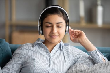 Huzurlu Hintli kız en sevdiği melodiyi kablosuz kulaklıkla dinliyor.