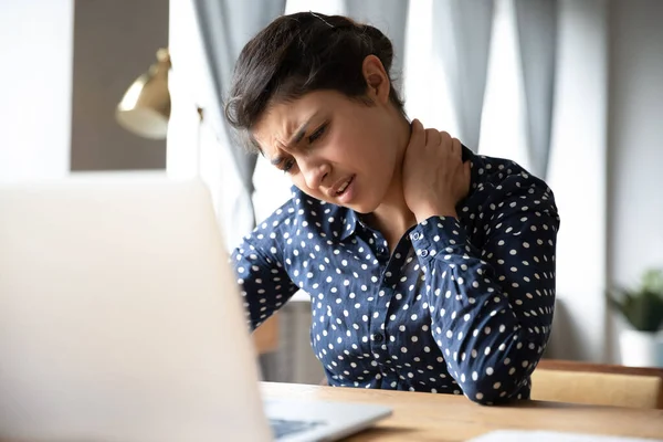 Indian woman sitting at desk touch neck feels pain — Stock Photo, Image