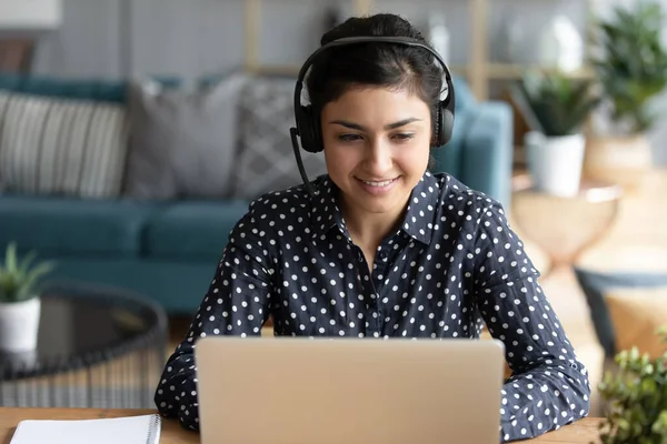 Indiase vrouw draagt headset neemt deel aan educatieve webinar met behulp van laptop — Stockfoto