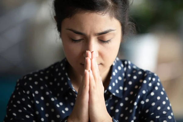 Primer plano religioso indio femenino cerrado ojos orando con las palmas dobladas — Foto de Stock