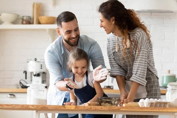 Gelukkig ouders met schattige kleine dochter hebben plezier met deeg — Stockfoto