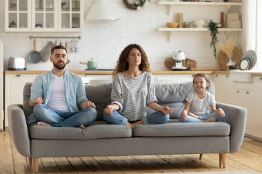 Küçük kızı yoga yapan barışçıl bir anne ve baba.