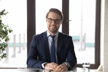 Masada oturan mutlu, kendinden emin genç erkek liderin portresi..