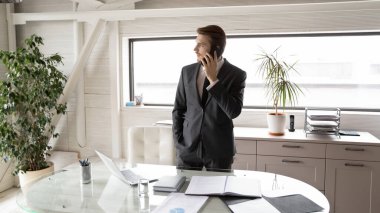 Akıllı telefon görüşmesi yapan konsantre genç yönetim kurulu başkanı..