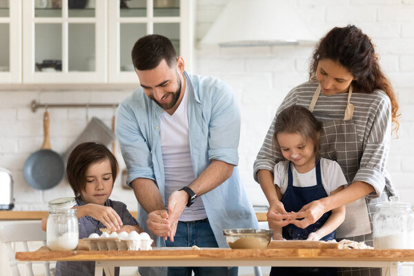 Happy mother and father with two kids baking together