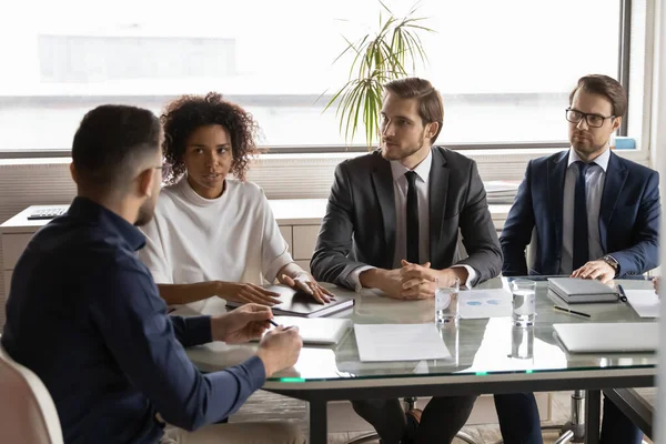 Des partenaires concentrés de jeunes entrepreneurs multiraciaux tiennent une réunion de négociation. — Photo