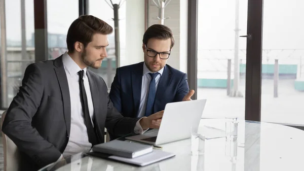 Socios comerciales masculinos jóvenes enfocados discutiendo la presentación en línea. — Foto de Stock