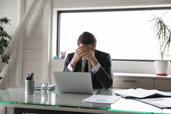 Infeliz joven gerente masculino que sufre de presión en el trabajo. — Foto de Stock