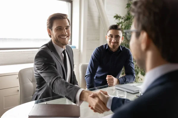 Des hommes d'affaires souriants se serrent la main, établissant un partenariat. — Photo