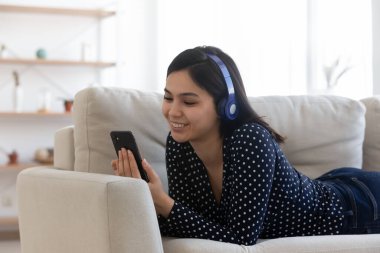 Gülümseyen Asyalı kızın cep telefonunda görüntülü arama var.