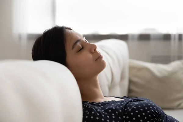 Calma donna etnica addormentarsi sul divano accogliente — Foto Stock