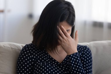 Mutsuz genç bir kadın kendini evinde sıkıntılı hissediyor.