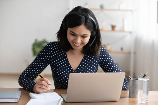 Smiling asian girl in headphones study distant on laptop — Stock Photo, Image