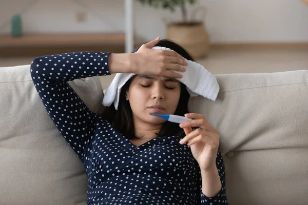 Нездорові азіатські дівчата вимірюють температуру вдома — стокове фото