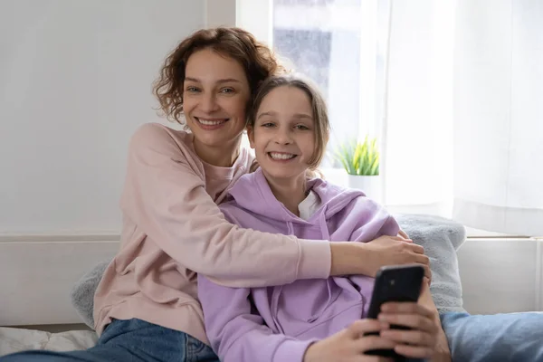 Gülümseyen anne ve genç kızın portresi evde rahatla. — Stok fotoğraf