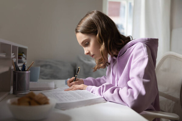 Smart teen girl study with textbook at home