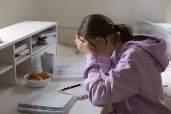 Несчастная девочка-подросток напряжена учебой дома — стоковое фото