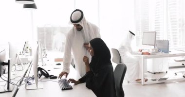 Arap erkek yönetici, kadın çalışana kurumsal yardım, destek, tavsiye veriyor, başvuru işini açıklıyor, işçi kadın monitörünü işaret ediyor, işyerinde duruyor.