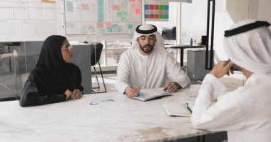 Erkek ve kadın Arap iş arkadaşları toplantı masasında konuşuyor, takım çalışması stratejisi, ortaklık, proje için planlama görevleri, başlangıca yatırım, pazarlama araştırmalarını analiz