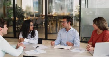 Genç 30 'lu yaşlardaki işadamı çeşitli personel üyeleriyle gayri resmi toplantılar yapıyor, gülerken olumlu konuşmalar yapıyor, olumlu haberler paylaşıyor, iyi iş sonuçları veriyor. Müzakereler, iş ilişkileri