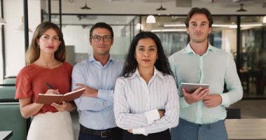 Dört başarılı çok ırklı takım üyesinin portresi ofiste birlikte poz veriyor, tablet ve organizatörü tutuyor, müzakerelere hazır, profesyonelliği yayıyor, şirket hizmetlerini temsil ediyor. Takım çalışması.