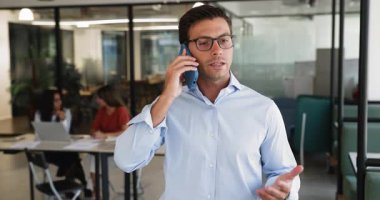 Yakışıklı İtalyan işadamı günümüzün iş yerinde elinde akıllı bir telefonla duruyor, resmi bir konuşma yapıyor, şirket müşterilerine telefonla danışmanlık yapıyor. Dijital, uzak, iş iletişimi