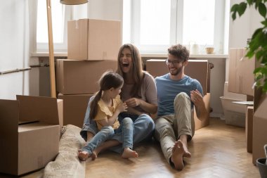 Kahkahalarla yerleşti. Heyecanlı, genç, evli ve kızı olan bir çift kutuların arasında gıdıklama oyunu oynuyorlar. Yeni bir eve taşınmanın tadını çıkarıyorlar.