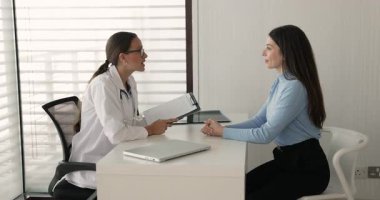 Muayene toplantısından sonra genç doktor ve hasta el sıkışıyor. İyileşmek isteyen, el sıkışan, iyileşmeyi kutlayan bir kadın doktor.