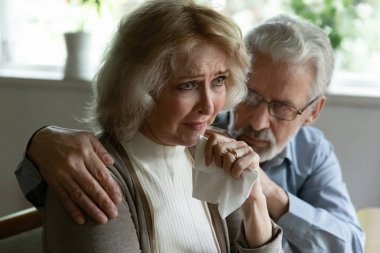 Ben seninleyim. Destekleyici, olgun, gri saçlı koca, rahatlatıcı, ağlayan eş, kötü haber, acı çeken kadın. Yaşlı erkek mutsuz eşinin omuzlarına sarılıyor. Aile içi anlaşmazlıktan sonra özür diliyor.