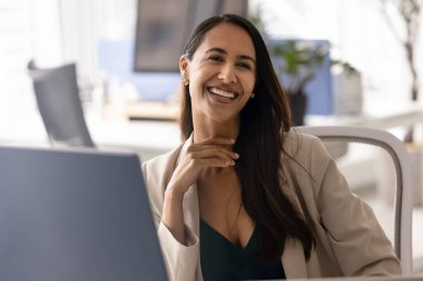 İşyerinde bilgisayar monitörüyle oturan başarılı bir yönetici kadın dişlek bir gülümsemeyle başka tarafa bakıyor. Genç Yeni Zelandalı iş kadını, hırslı profesyonel portre.