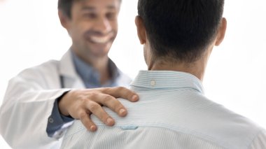 Dostane tıbbi destek. Yakın çekim mutlu doktor hasta erkek omuza dokunur. Doktor hasta kişi konsepti arasındaki duygusal bağın iyileşmesini kutlayan sıcak empati ile iyi haberler veriyorum.