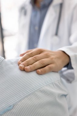 Hastalıklara karşı yalnız değilsin. Yakın çekim doktor hasta erkek hastanın omuz omuza şefkatli elini tutuyor. Umut desteği vermek iyi sonuç ile güven vermek empati kavramını ifade etmek
