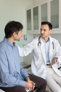 Doktor ve hasta arasındaki bağ ve güven. Bakıcı erkek tıbbi destek, klinik ziyareti sırasında hasta adamı rahatlatıyor. Teşhisten kaynaklanan stresin azalmasına yardımcı oluyor.