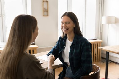 Yardım edebildiğime sevindim. Neşeli genç bayan, başarılı eğitim koçluğu kariyeri danışmanlığı seansından sonra minnettar bayan stajyer stajyer ile profesyonel danışmanlık uzmanının el sıkışmasını tecrübe etti.
