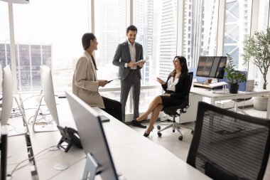 Çeşitli pozitif iş arkadaşları ofis alanındaki takım çalışması için kısa günlük toplantılar planlıyorlar, konuşuyor ve gülüyorlar, yenilikçi fikirler üzerinde beyin fırtınası yapıyorlar, işbirliğinden keyif alıyorlar.