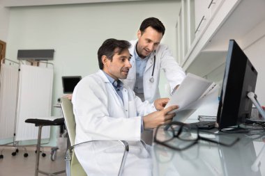 Profesyonel merak ve işbirliği. İlgili tıbbi ekip. İki orta yaşlı erkek doktor. Olağandışı hasta vakalarını inceliyorlar.