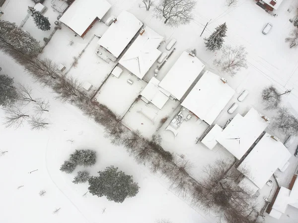 High level of snow storm, winter weather forecast alert day in the city. Top aerial view of people houses covered in snow, bird eye view suburb urban housing development. Quite neighbourhood, Canada.