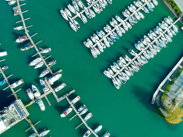Beautiful boats. Aerial view of boats in morning Ontario lake bay in Canada. Summer lake with ships and yachts in calm clear beach water in sunny day. Top view from flying drone.
