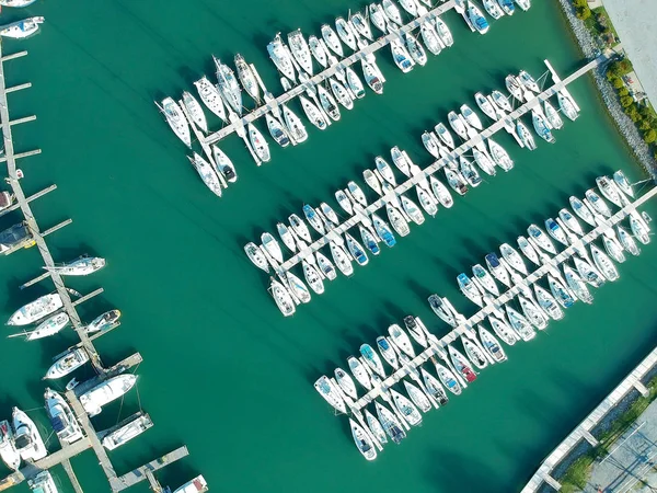Beautiful boats. Aerial view of boats in morning Ontario lake bay in Canada. Summer lake with ships and yachts in calm clear beach water in sunny day. Top view from flying drone.