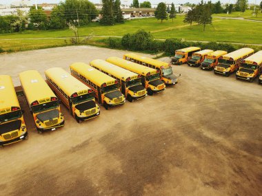 Satır sarı okul otobüs genç öğrenci eğitim sezonu için bekleyen olmadan park yerinde ağaçlar karşı. Geri okul kavramı. Uçağı hava kuş bakışı manzaralar.