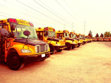 Okul otobüsü araçlar okul eğitim sezonu için hazır. Filtre uygulanmış etkisi. Sarı parça ve akşam gökyüzünde almak ve genç üniversite öğrencileri damla hazır bahçesinde otopark. Geri okul kavramı.